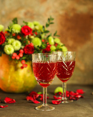 red wine in a glass and flowers on a wooden background. top view.