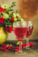 red wine in a glass and flowers on a wooden background. top view.