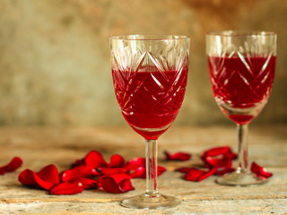red wine in a glass and flowers on a wooden background. top view.
