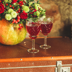 red wine in a glass and flowers on a wooden background. top view.