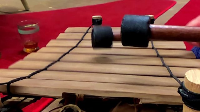 A close up view of a tune being played on a Balafon