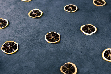 Dried sliced lemon on dark texture surface. Macro shot of fruits.