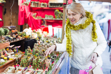 Woman is preparing for Christmas and choosing decorations for her house