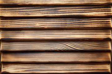 Burnt wood texture. Horizontal burnished wooden planks closeup view.