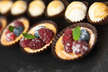 Beautiful fruit desserts in black background. Catering closeup view.