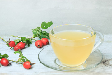 Rosehip tea in glass cup on the wooden table