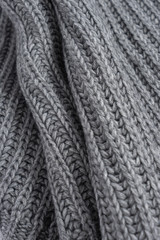 Grey woolen knitted scarf. Closeup view texture with bokeh.