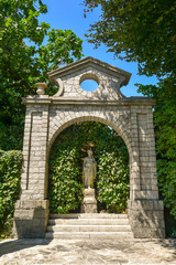Dettaglio di un giardino in stile classico con statua e siepe verde in estate, Stresa, Lago Maggiore, Piemonte