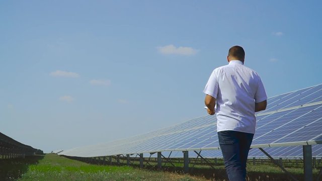 Man walking along the solar panel