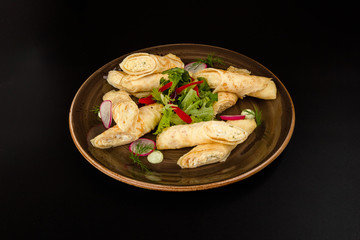 Hand-made stuffed and simple round pancakes on plates close-up.