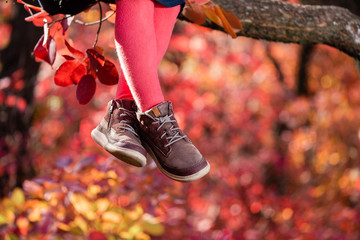 Baby girl legs sitting on tree branch