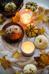 Obraz na płótnie Canvas Burning candle in jar, autumn leaves and small decorative pumpki