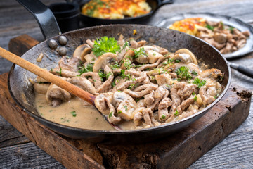 Traditional Swiss zürcher geschnetzeltes with rösti as closeup in a wrought-iron pan