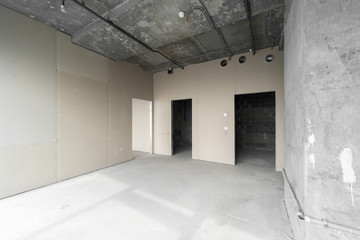 Perspective view of empty cement floor and ceiling interior with city skyline view