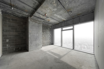 Perspective view of empty cement floor and ceiling interior with city skyline view