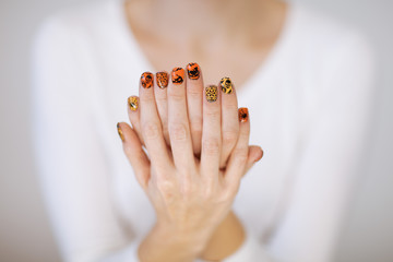 Beautiful woman hands with cute halloween nail polish can be used as background