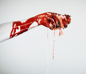 Creepy bloody horror Halloween monster witch hand with white, red and black make up and long creepy...