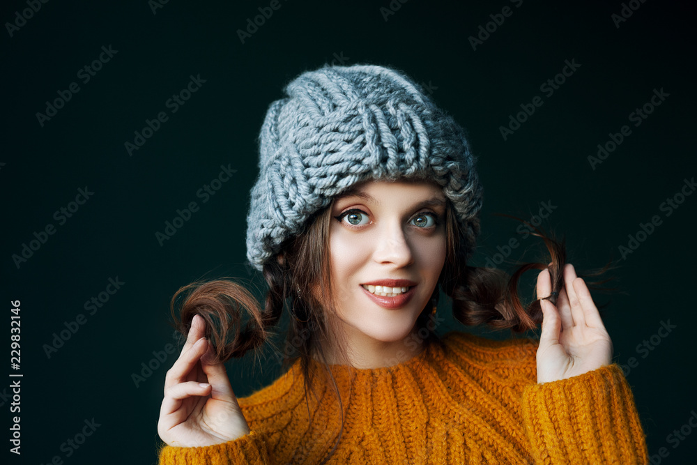 Wall mural close up studio portrait of young beautiful happy smiling girl wearing stylish gray beanie hat and y