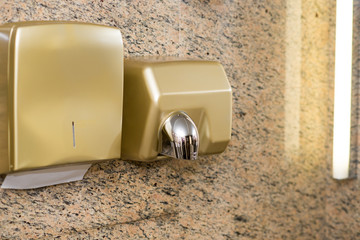 Paper Dispenser and hand dryer on the wall in public toilet