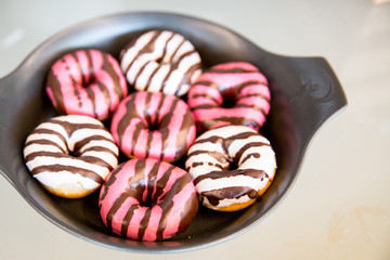 white and pink donuts with chocolate