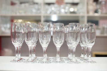 Crystal clear empty wine glasses on the table. Alcohol background. A lot of wine glasses at the bar