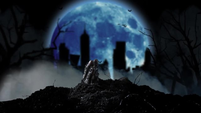 From the grave slowly emerging human hand in the background cemetery and moon. Smoky background