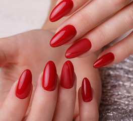 Bright festive red manicure on female hands. Nails design.