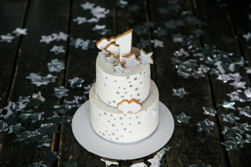 First birthday white cake with stars and one candle for little baby boy and decorations for cake smash. Black background