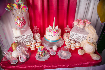 Candy bar for the first birthday for little baby girl. Sweet table and big unicorn cake