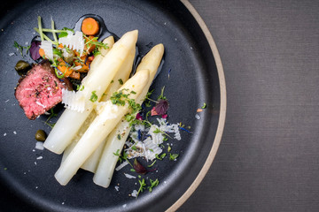 Modern Style classic white asparagus with barbecue dry aged sliced beef fillet and vegetable served...