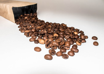 coffee beans are poured from a Kraft paper bag, isolated on a white background