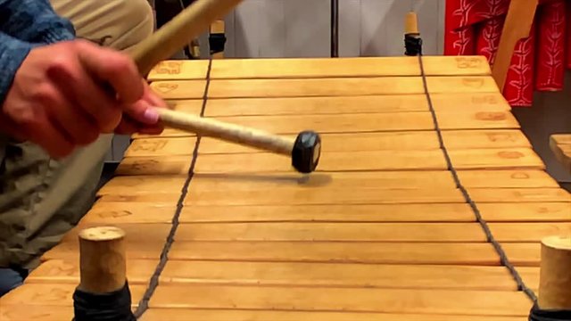 A close up view of a tune being played on a Balafon