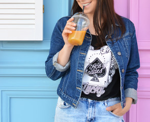 Healthy lifestyle. The brunette girl drinks fresh juice through a straw. Orange fresh.