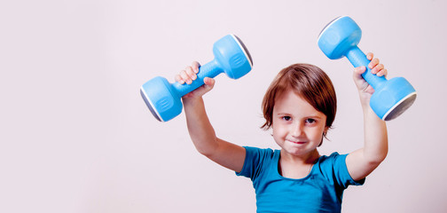 Naklejka premium Little cute female sportler with dumbbells as symbol of best investment in health of children in future. Winner, fitness, sport, training, lifestyle concept.