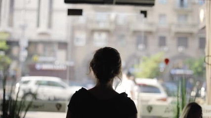 Woman silhouette with bag goes outside to the street
