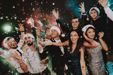 Obraz na płótnie Canvas People in Santa Claus Cap Celebrating New Year.