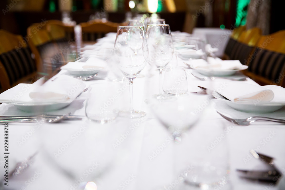 Wall mural Beautifully decorated table with empty white plates, glasses and cutlery  on luxurious tablecloths