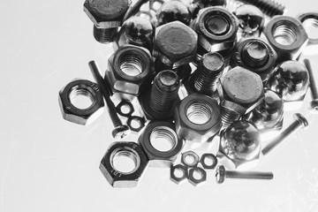 Art monochrome background from bolts and nuts close up in blue backlight. Macro photography of handful of fasteners. Copy space.