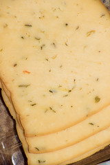 Slices of yellow cheese with herbs and spices