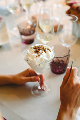Woman's hands tasting and enjoying a cold dessert in a glass.