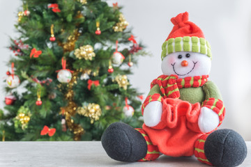 Decorated little christmas tree and a snowman seeting on white background