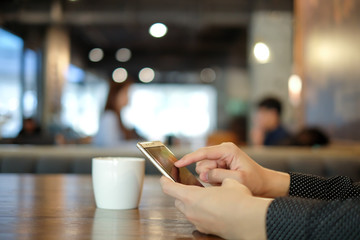 Man hand touch on mobile smartphone in cafe.