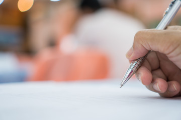Business Concept : Hand Businessman holding silver pen to taking notes on white paperwork or...