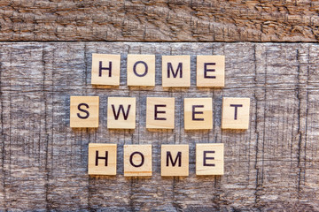 Inscription HOME SWEET HOME letters word on wooden backdrop. Eco Village abstract environmental background. Real estate mortgage property insurance ecology concept. Flat lay top view copy space