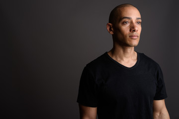 Fototapeta premium Handsome bald man wearing black shirt and thinking