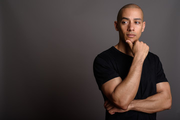 Handsome bald man wearing black shirt and thinking