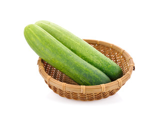 whole fresh cucumbers in bamboo basket on white background