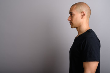 Profile view of handsome bald man wearing black shirt