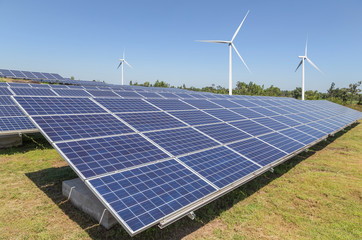    solar cells with wind turbines generating electricity in hybrid power plant systems station on blue sky background alternative renewable energy from nature  