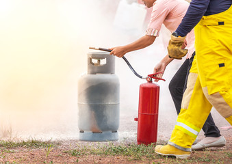 Volunteer using fire extinguisher from hose for fire fighting during basic fire fighting training and fire drill evacuation